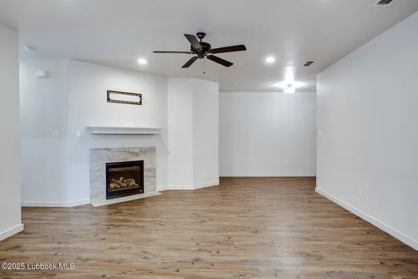 a view of an empty room with a fireplace and a window