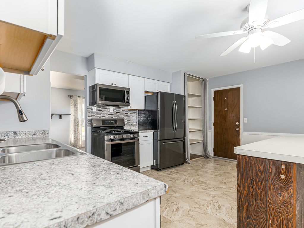 78 Springdale Road Montgomery, IL 60538 - Photo 6 of 21 a kitchen with stainless steel appliances kitchen island granite countertop a refrigerator stove and sink