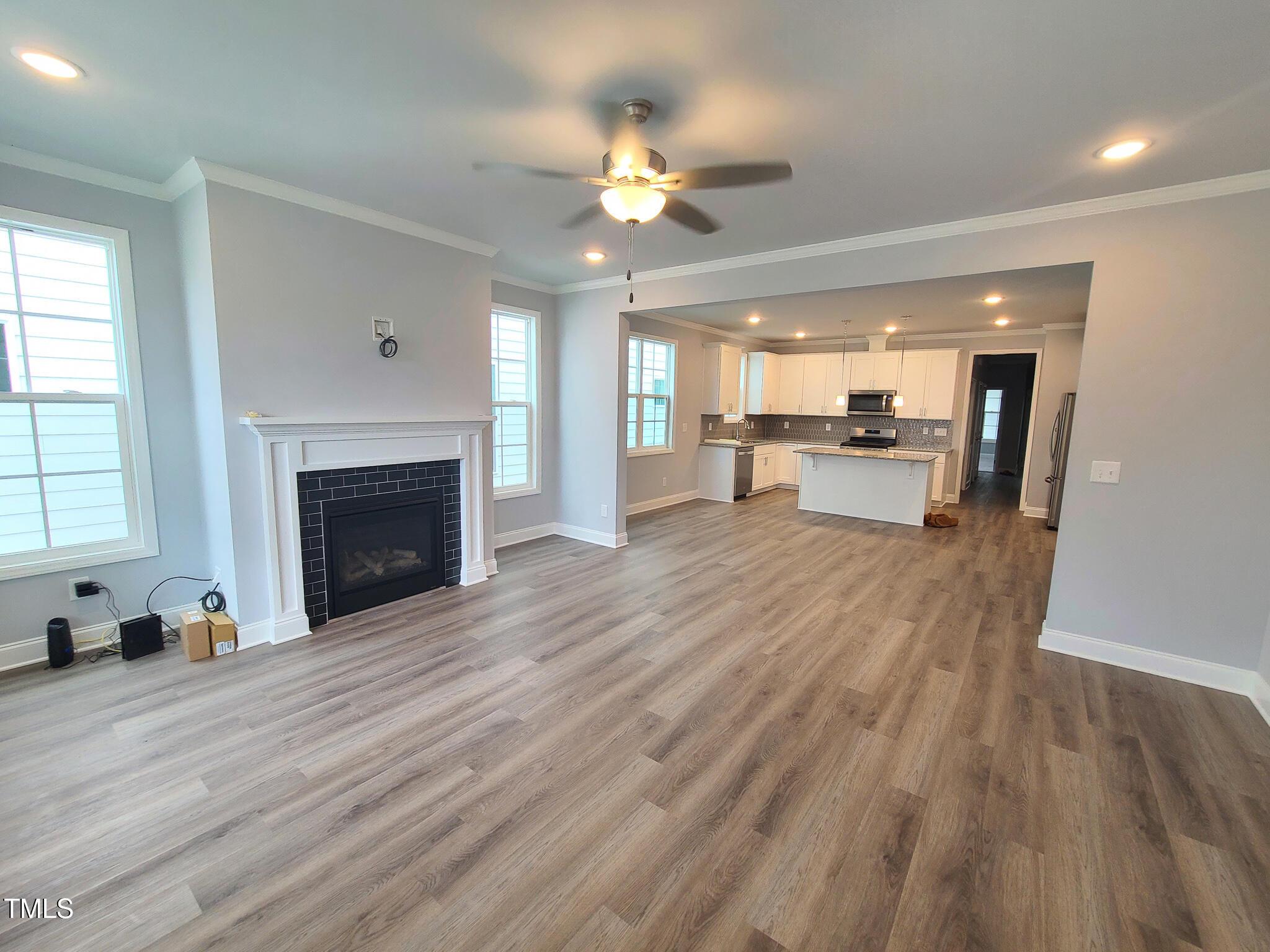 1629 Glazebrook Drive Wake Forest, NC 27587 - Photo 3 of 35 a view of a livingroom with fireplace a chandelier fan and wooden floor