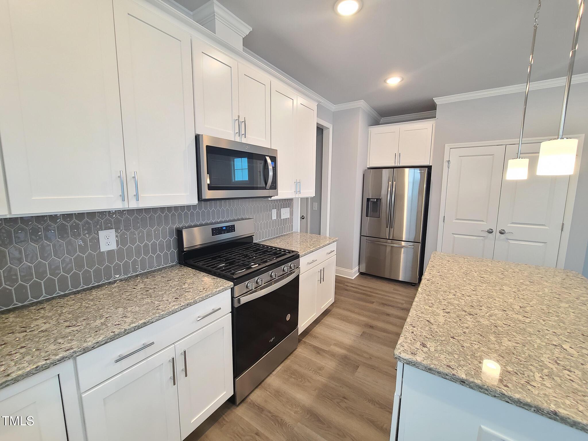 1629 Glazebrook Drive Wake Forest, NC 27587 - Photo 5 of 35 a kitchen with stainless steel appliances granite countertop a refrigerator stove and microwave