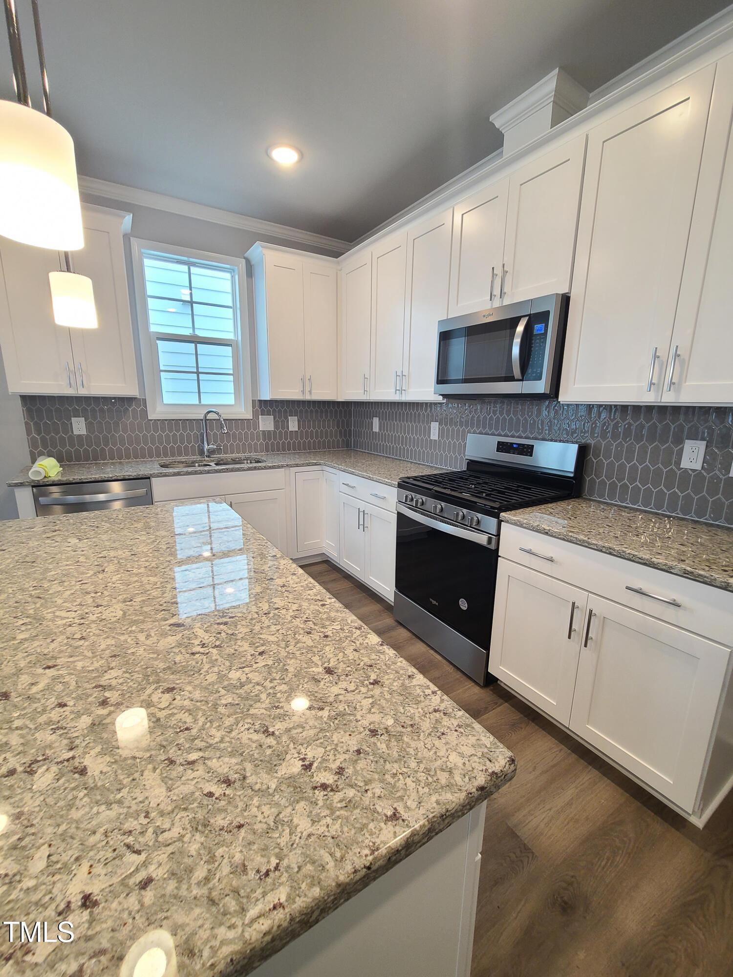 1629 Glazebrook Drive Wake Forest, NC 27587 - Photo 6 of 35 a kitchen with stainless steel appliances granite countertop a sink stove and refrigerator