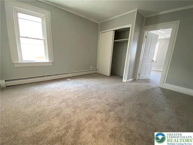 an empty room with windows and closet