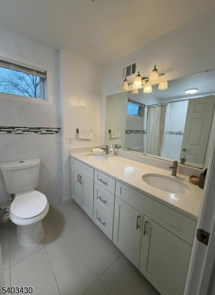 49 Blaine Street Millburn, NJ 07041 - Photo 6 of 10 a bathroom with a toilet sink and mirror