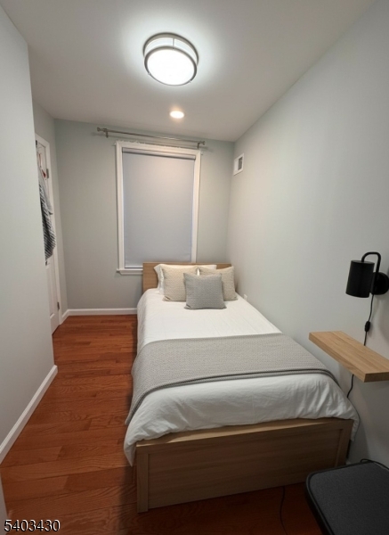 49 Blaine Street Millburn, NJ 07041 - Photo 9 of 10 a bedroom with a bed and a lamp with the wooden floor
