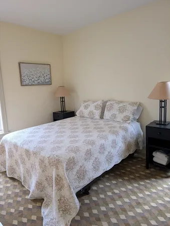 a bedroom with a bed and a lamp on table