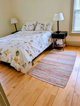 a bedroom with a bed and a lamp on dresser