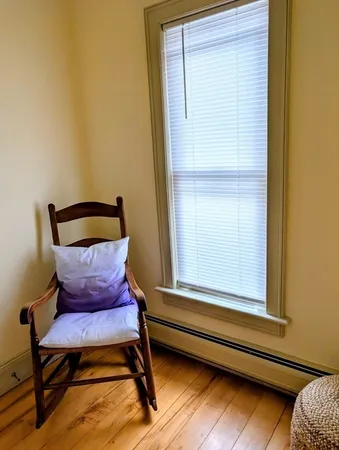 a wooden bench sitting in a bedroom next to a window