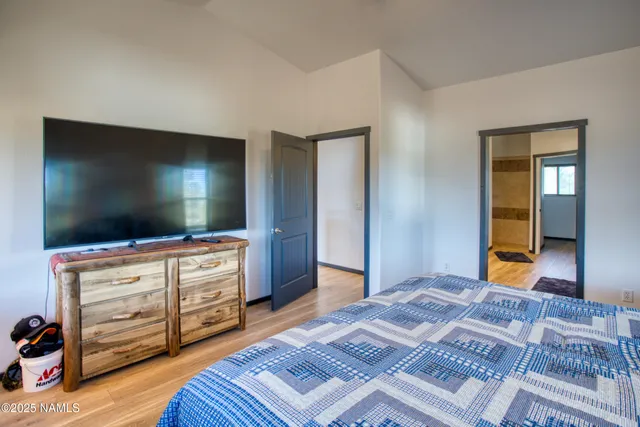 a bedroom with a bed and a flat screen tv