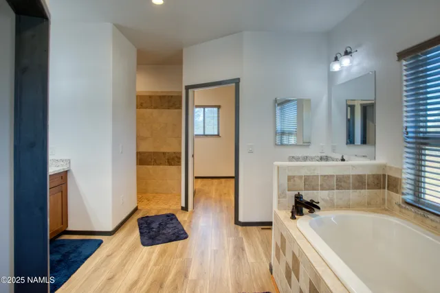 a bathroom with a tub a sink and a large mirror
