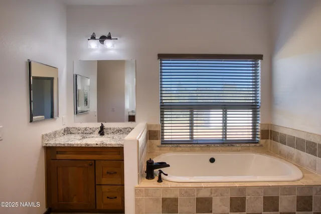 a bathroom with a tub sink and mirror