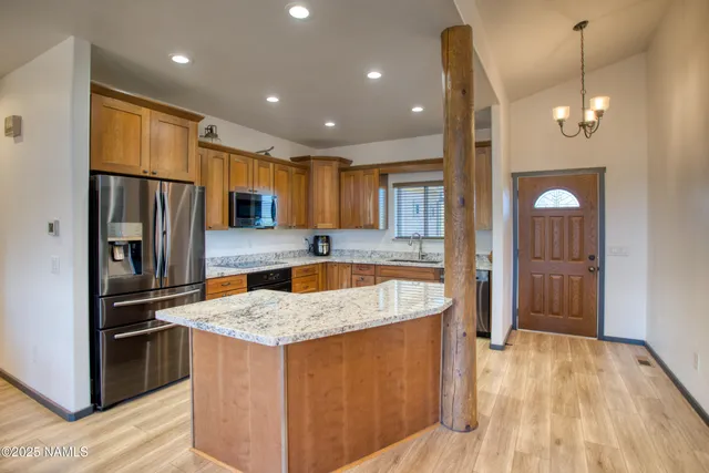 a kitchen with stainless steel appliances granite countertop a refrigerator a sink and a stove