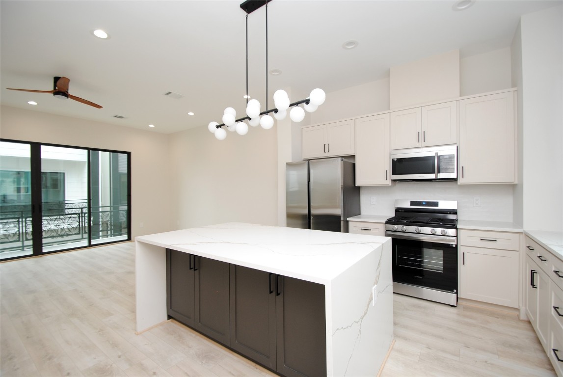 6310 Illinois Street, Unit A Houston, TX 77021 - Photo 7 of 22 a kitchen with a sink a stove a microwave and refrigerator