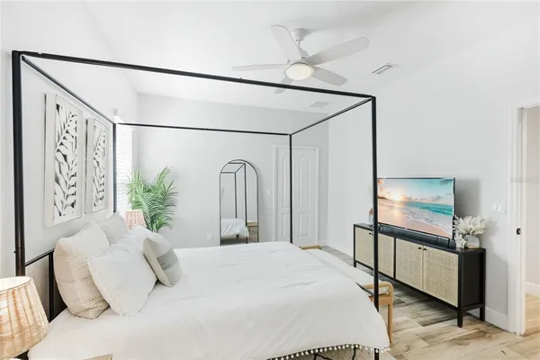 a bedroom with a large bed and a chandelier