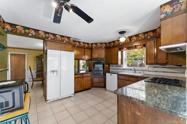 a kitchen with stainless steel appliances granite countertop a sink and a refrigerator