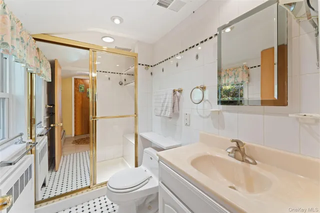 a bathroom with a sink a toilet a glass door shower and a mirror