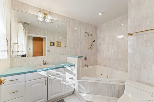 a bathroom with a bathtub a double vanity sink and mirror