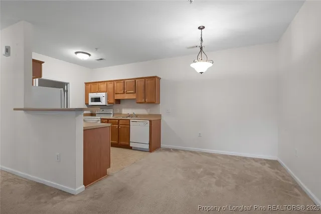 a kitchen with stainless steel appliances granite countertop a sink a stove a refrigerator and cabinets