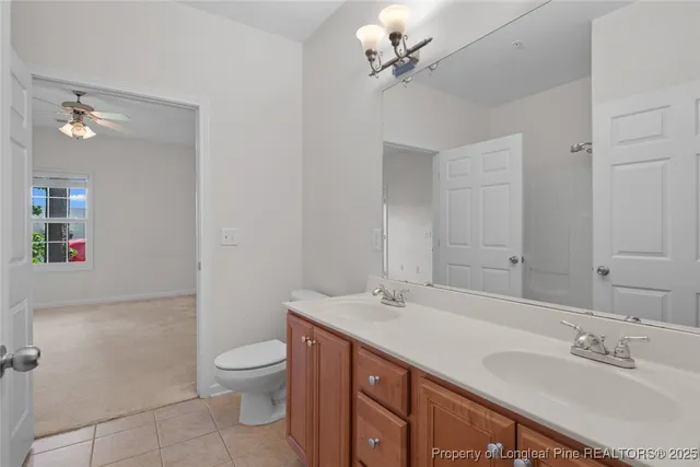 a bathroom with a double vanity sink toilet and a mirror