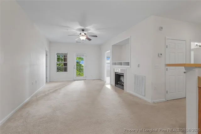a view of a livingroom with a fireplace and window