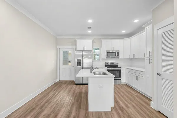 a kitchen with sink a microwave and cabinets