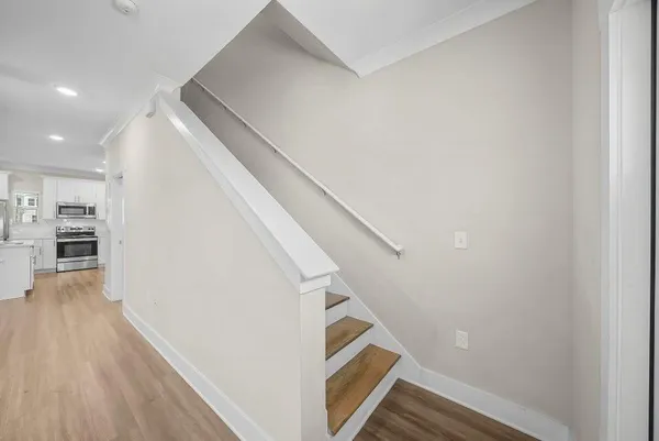 a view of a hallway with wooden floor and staircase