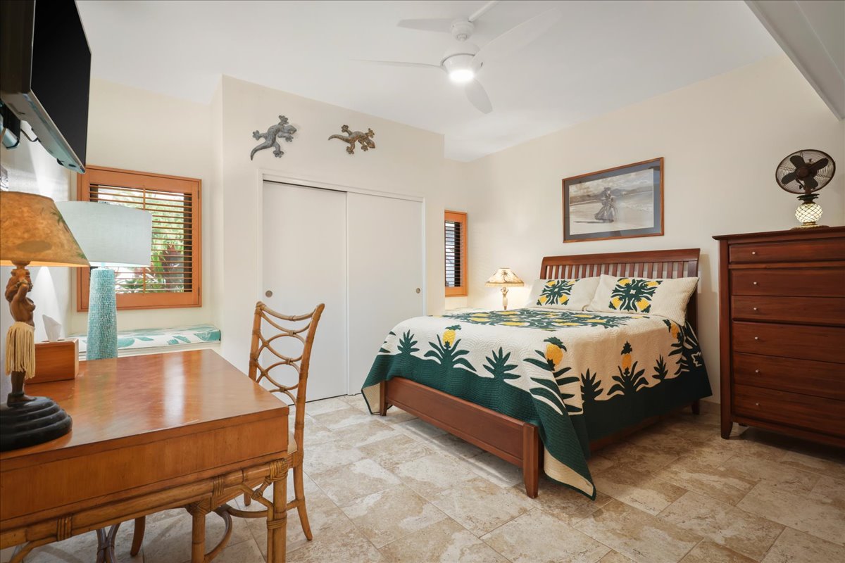 75-6040 Alii Drive, Unit 303 Kailua-Kona, HI 96740 - Photo 14 of 24 a bedroom with a bed and a table in it