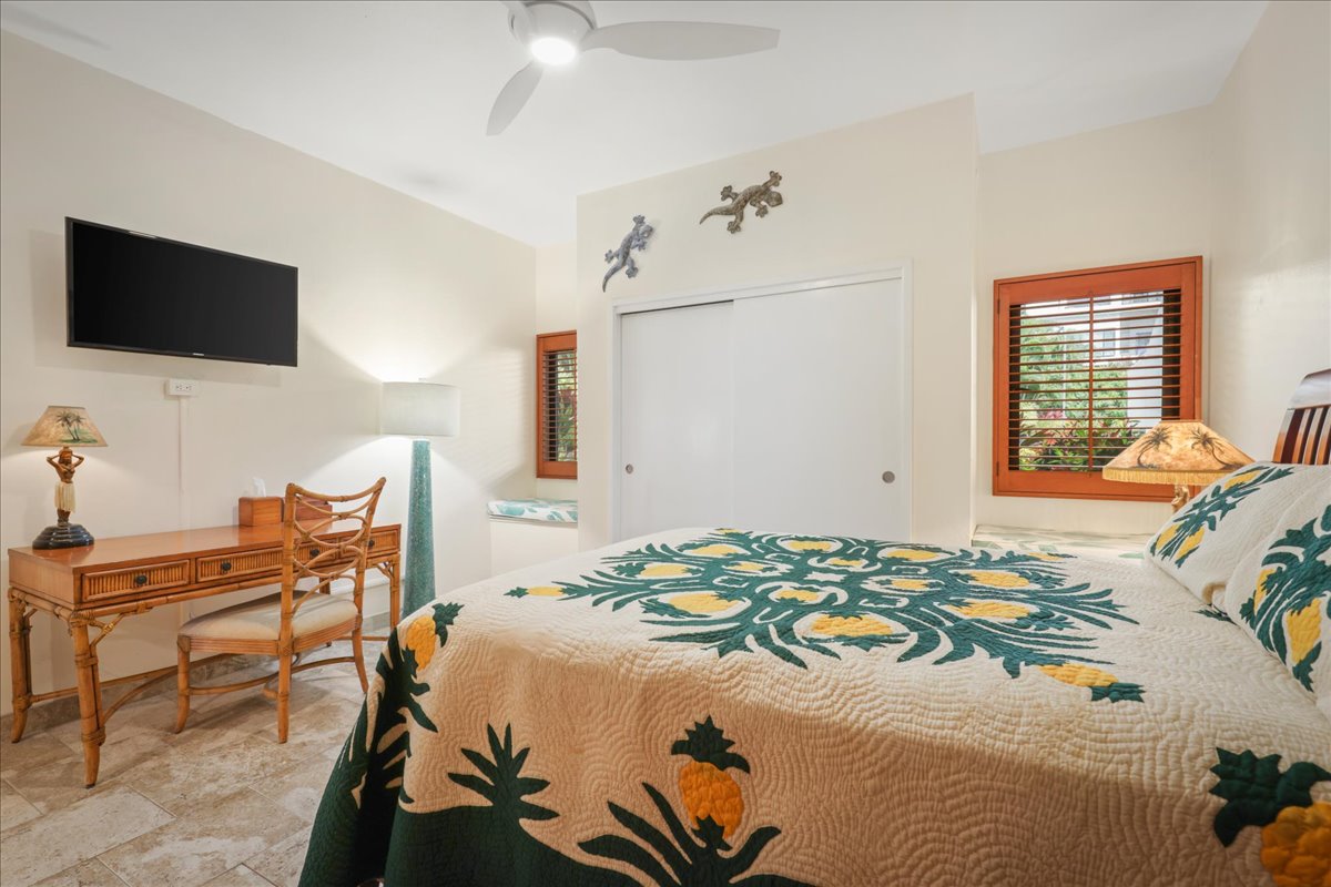 75-6040 Alii Drive, Unit 303 Kailua-Kona, HI 96740 - Photo 15 of 24 a bedroom with a bed and a flat screen tv