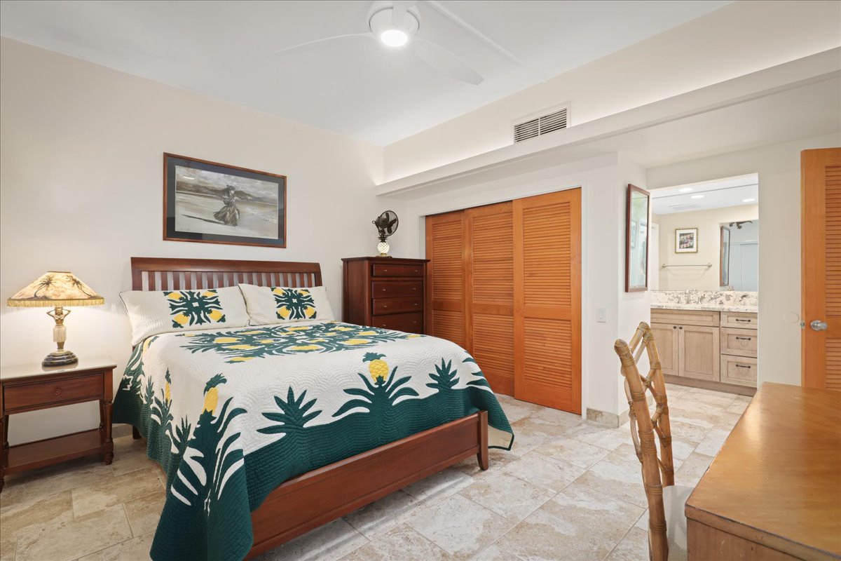 75-6040 Alii Drive, Unit 303 Kailua-Kona, HI 96740 - Photo 16 of 24 a bedroom with a bed table flowerpot and a window