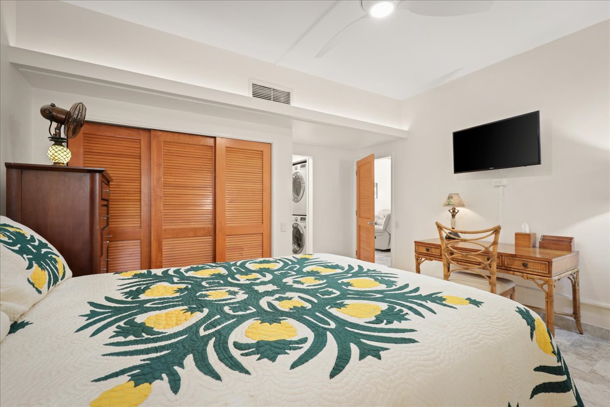 75-6040 Alii Drive, Unit 303 Kailua-Kona, HI 96740 - Photo 17 of 24 a bedroom with a bed and a flat screen tv