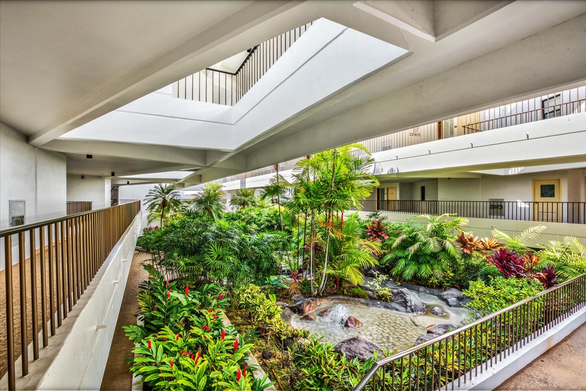 75-6040 Alii Drive, Unit 303 Kailua-Kona, HI 96740 - Photo 22 of 24 a front view of a house with a garden