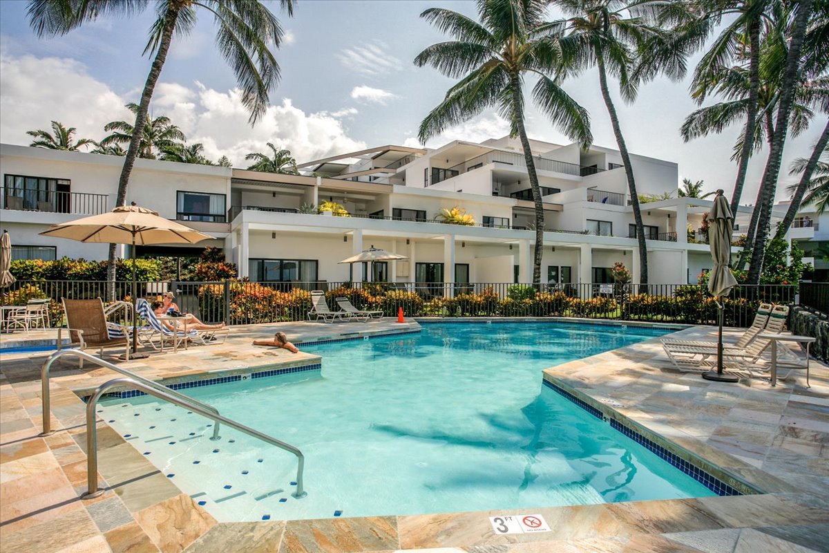 75-6040 Alii Drive, Unit 303 Kailua-Kona, HI 96740 - Photo 24 of 24 a view of a swimming pool with a table and chairs