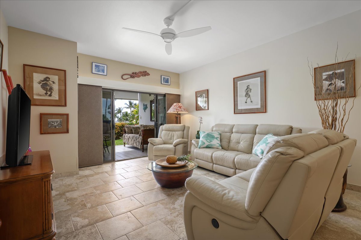 75-6040 Alii Drive, Unit 303 Kailua-Kona, HI 96740 - Photo 5 of 24 a living room with furniture and a flat screen tv