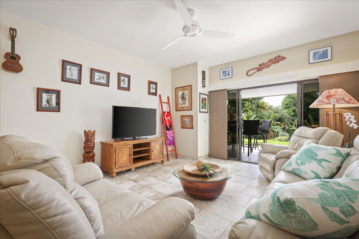 75-6040 Alii Drive, Unit 303 Kailua-Kona, HI 96740 - Photo 6 of 24 a living room with furniture and a flat screen tv