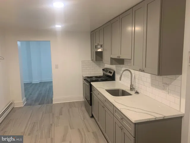 a kitchen that has a sink and a stove in it