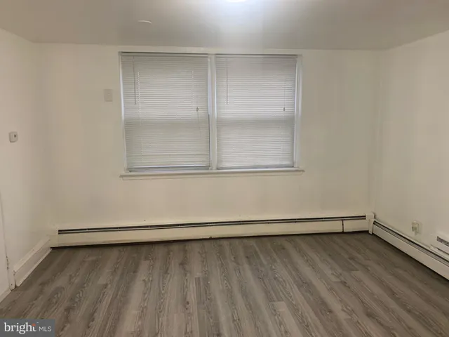 a view of a small space with wooden floor and a window