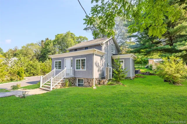 a view of a house with backyard and a tree