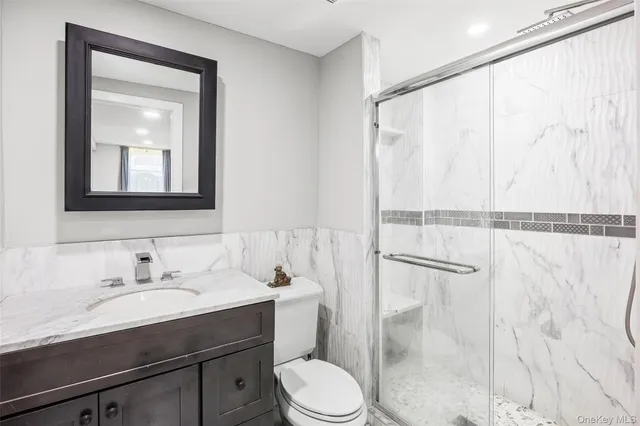 a bathroom with a sink vanity mirror and toilet
