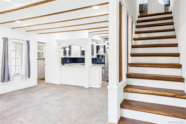 a view of a livingroom with wooden cabinets and a window