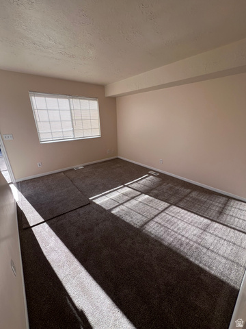 556 North Fairfield Road, Unit D4 Layton, UT 84041 - Photo 4 of 23 Carpeted spare room with a textured ceiling and baseboards