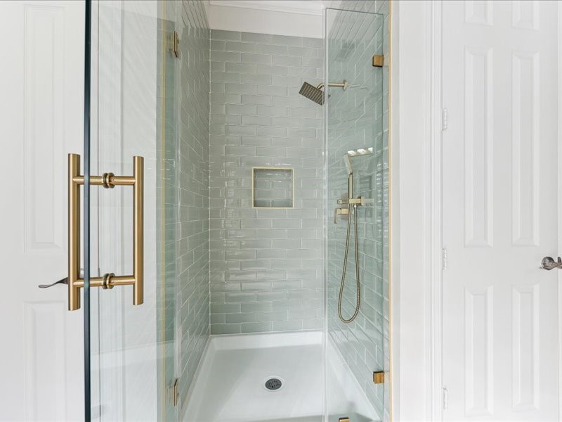 11404 Island Manor Street Pearland, TX 77584 - Photo 24 of 42 A never-used, newly remodeled primary frameless tile shower showcases timeless brass fixtures and exceptional craftsmanship.