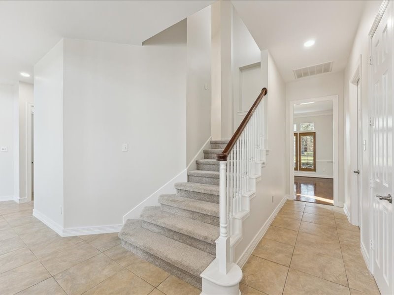 11404 Island Manor Street Pearland, TX 77584 - Photo 26 of 42 Dual staircases enhance the home’s thoughtful design, creating a seamless connection from the entry to the kitchen and living areas.