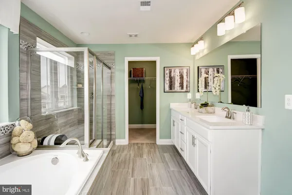 a kitchen with stainless steel appliances granite countertop a stove top oven a refrigerator a sink and white cabinets