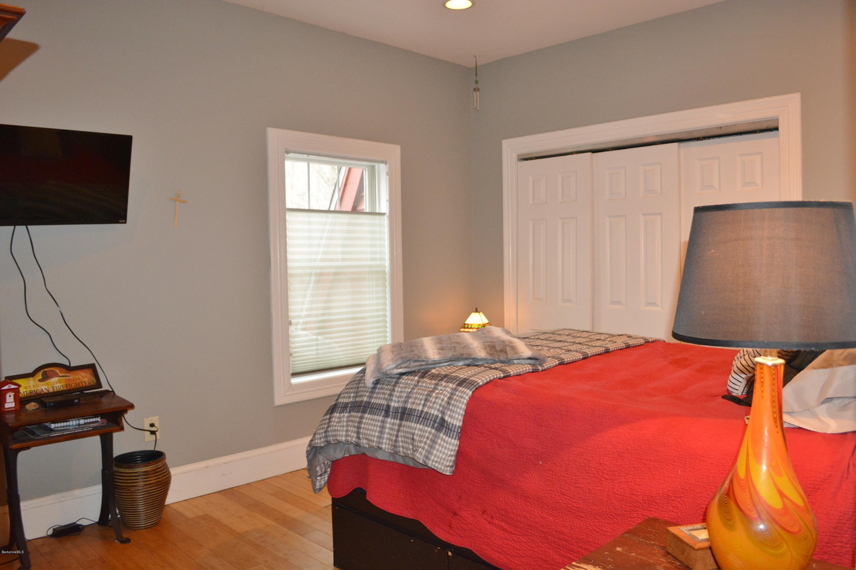 27 Kibbe Point Road Otis, MA 01029 - Photo 23 of 30 a bedroom with a bed and wooden floor