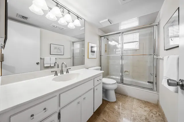 a bathroom with a double vanity sink toilet and shower
