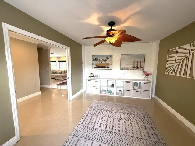 a living room with stainless steel appliances furniture a rug and a view of kitchen