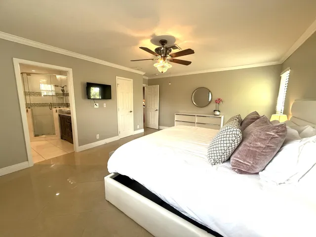 a spacious bedroom with a bed and a chandelier