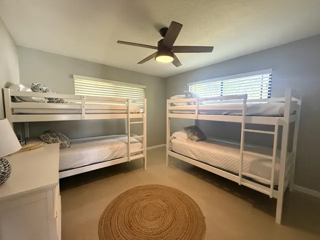 a bedroom with a bed and a ceiling fan
