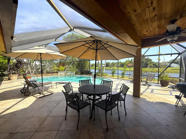 a view of a patio with a table chairs and a backyard