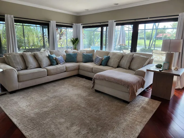 a living room with furniture and large windows