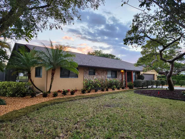 a view of a house with backyard and a tree